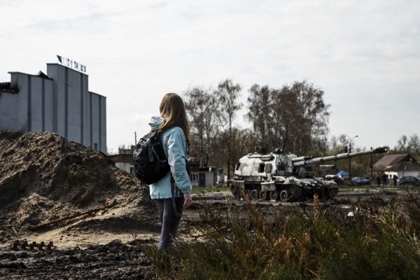 Girl looks at a destoyed Tank