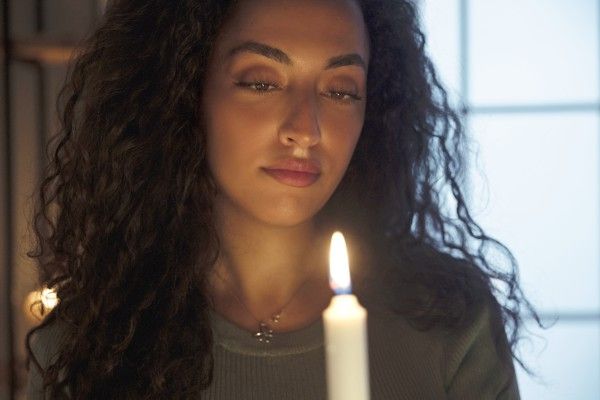 young woman holds candle